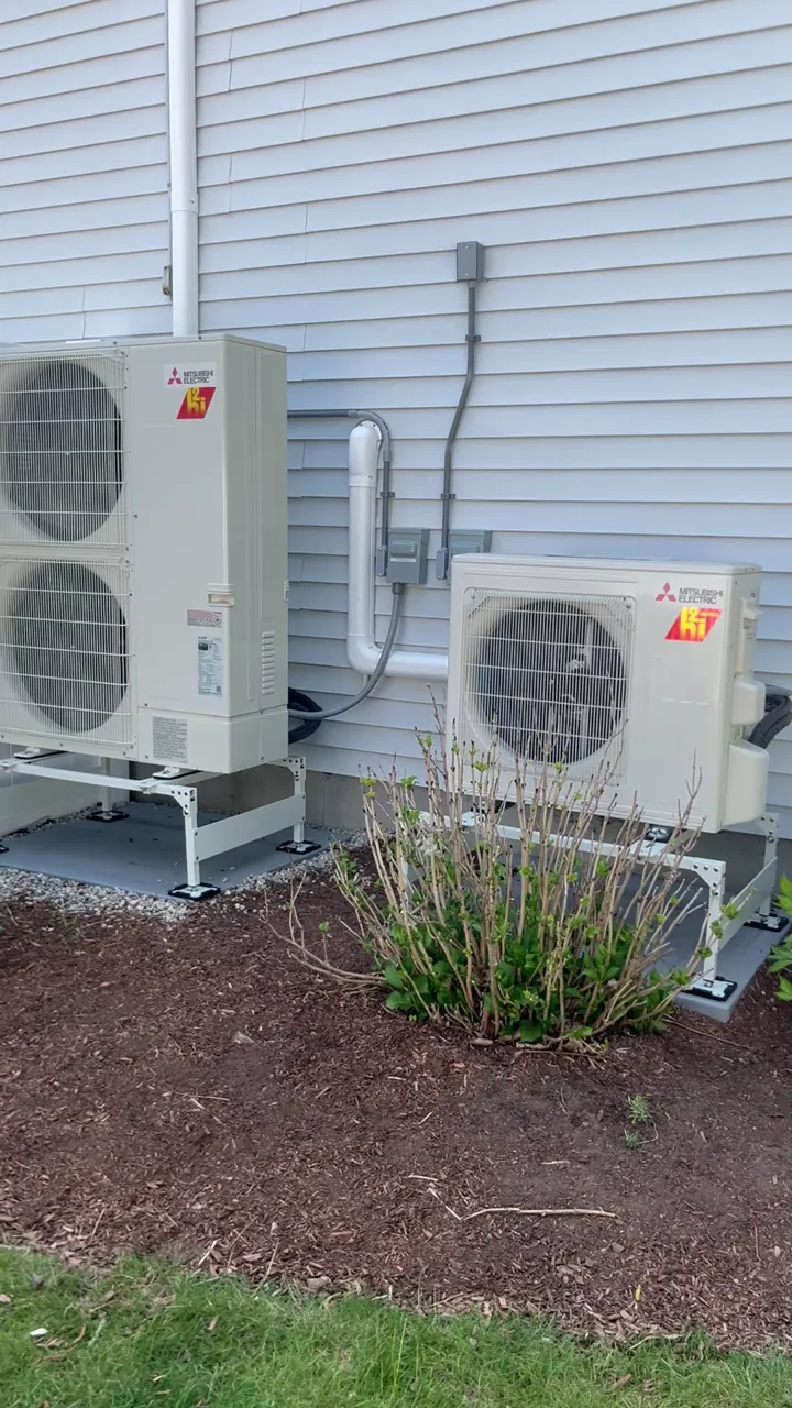 Two mini-split condensers set clean on the side of the home