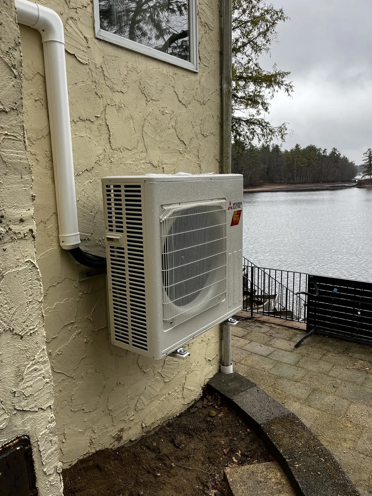 Bracket-mounted condenser overlooking the water by TJM Climate Control, Southern NH & northern MA
