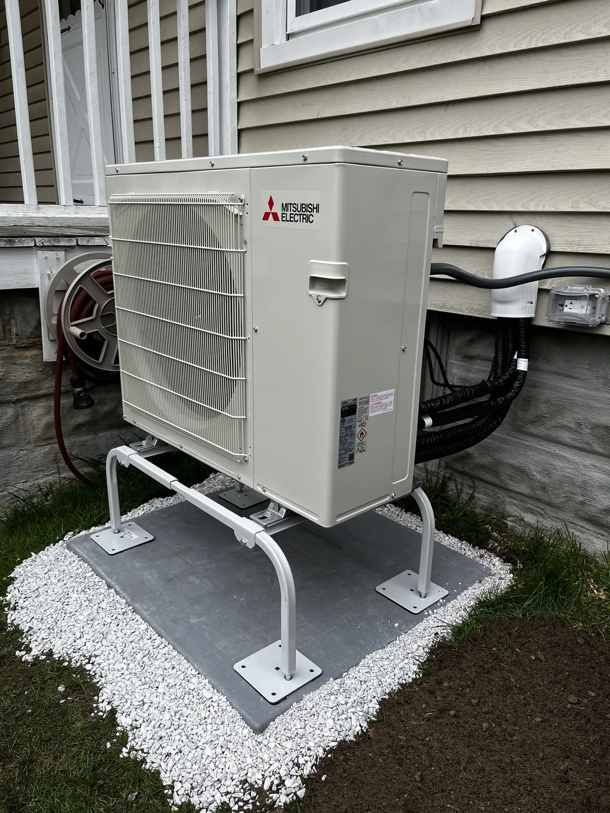 Cold-climate condenser on a stand and composite pad by TJM Climate Control, Southern NH & northern MA